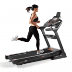 A woman in athletic attire running on the F63 treadmill