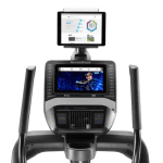 Console of the Nordictrack FS9i trainer with an image of a woman conducting a workout. The treadmill includes a cup holder, a tablet holder, a fan, a speaker and several buttons