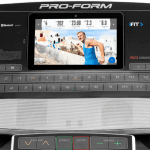 Console of the ProForm Smart Pro 5000 Treadmill. This features a digital screen of a man conducting a workout, a speaker, a fan and several buttons