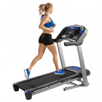 A fit woman in athletic attire running on the Horizon T101 Treadmill
