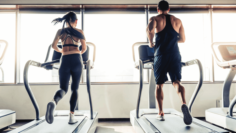 man and woman running on treadmills
