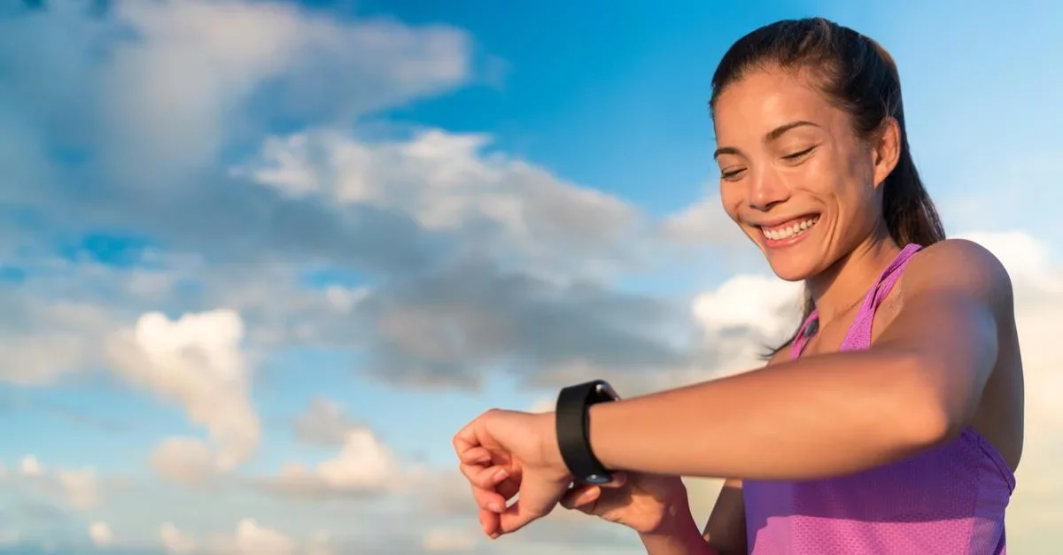 Woman checking fitness tracker on run